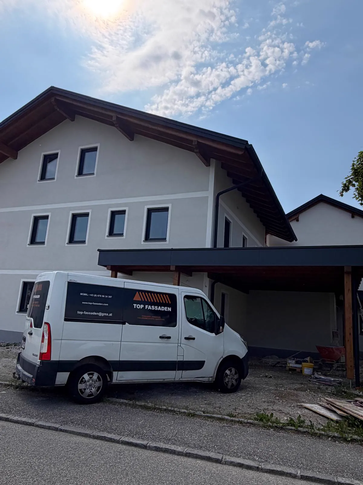 Firmenfahrzeug vor einem fertiggestellten Objekt